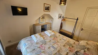 a bedroom with a bed with books on it at Pepperpot in Portreath
