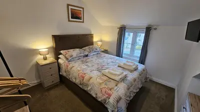 a bedroom with a bed with towels on it at Pepperpot in Portreath