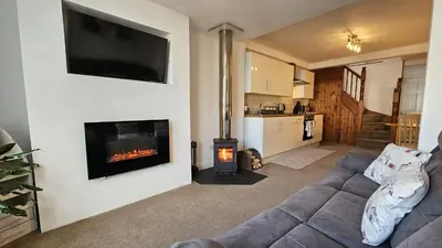a living room with a couch and a fireplace at Pepperpot in Portreath
