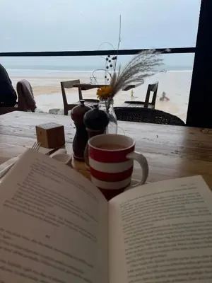 a book on a table with a cup and a coffee mug at Holywell View 30 in Cubert