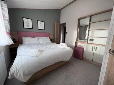 a bedroom with a large bed with white sheets at Holywell View 30 in Cubert