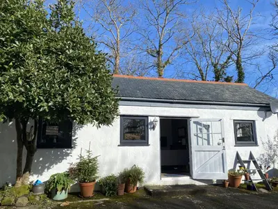 a small white house with a white garage at Pond Cottage in Coverack