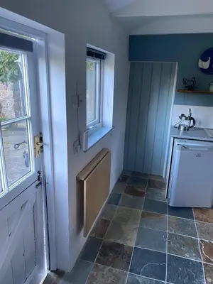 a small kitchen with a sink and a door at Pond Cottage in Coverack