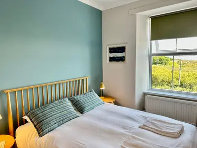 a bedroom with a large bed with a window at St George's Hotel in Perranporth