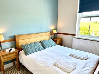 a bedroom with a bed with two pillows and a window at St George's Hotel in Perranporth
