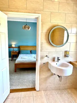 a bathroom with a sink and a bed with a mirror at St George's Hotel in Perranporth