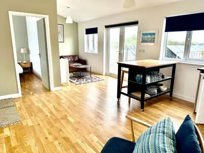 a living room with a wooden floor and a table at St George's Hotel in Perranporth