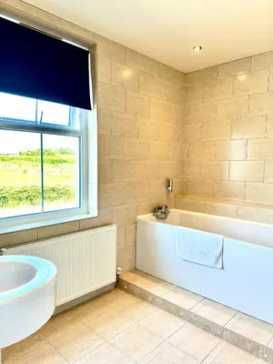 a bathroom with a tub and a sink and a window at St George's Hotel in Perranporth