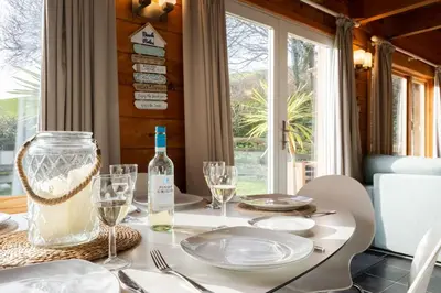 a dining room table with a bottle of wine on it at Hillview in Little Petherick