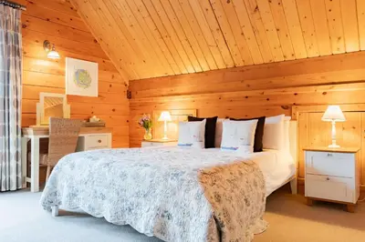 a bedroom with a bed in a wooden room at Hillview in Little Petherick