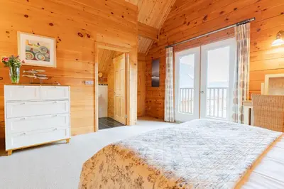 a bedroom with a bed and a large window at Hillview in Little Petherick