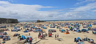 a large group of people on a beach at Perranporth HOT TUB 3 Bed Dog friendly Home in Newquay