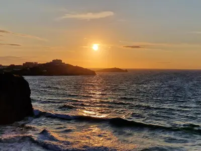 a sunset over the ocean with the sun setting at Perranporth HOT TUB 3 Bed Dog friendly Home in Newquay