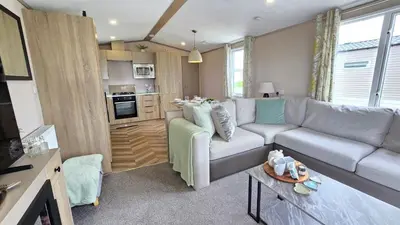 a living room with a couch and a kitchen at Perranporth HOT TUB 3 Bed Dog friendly Home in Newquay