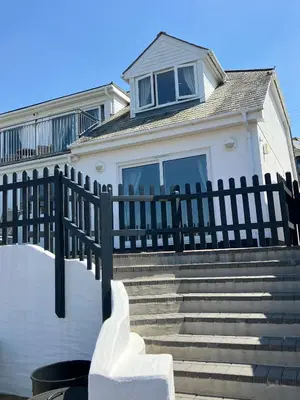a house with a fence in front of some stairs at Contemporary Holiday apartment in Perranporth