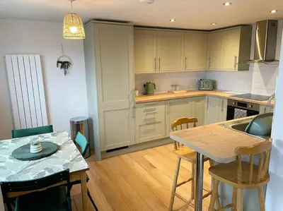 a kitchen with a table and some chairs in it at Contemporary Holiday apartment in Perranporth