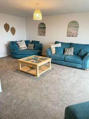 a living room with blue couches and a coffee table at Contemporary Holiday apartment in Perranporth