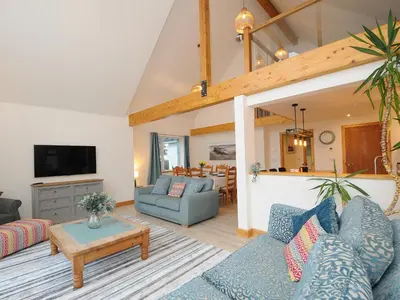 a living room with blue couches and a tv at Gwennel Neyth in Newquay