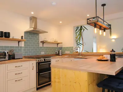 a kitchen with white cabinets and a counter top at Gwennel Neyth in Newquay