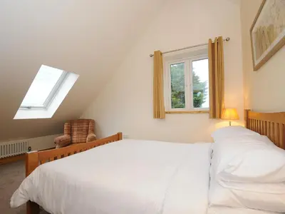 a bedroom with a white bed and a window at Gwennel Neyth in Newquay