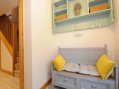 a gray bench with yellow pillows in a room at Gwennel Neyth in Newquay