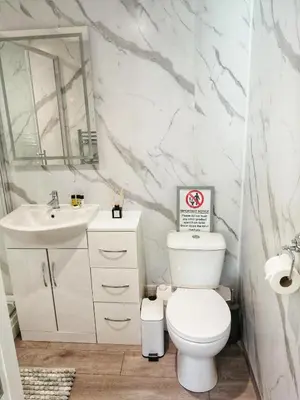 a bathroom with a toilet and a sink and a mirror at Valkyrie in Perranzabuloe