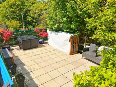 a patio with two chairs and a grill in a garden at Valkyrie in Perranzabuloe