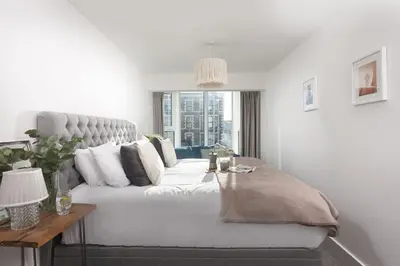 a living room with a white couch and a window at Bathsheba, Ocean 1 in Newquay