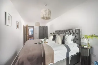 a bedroom with a large bed with white sheets and pillows at Bathsheba, Ocean 1 in Newquay