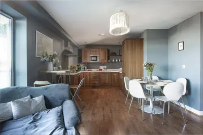 a living room with a couch and a table with chairs at Bathsheba, Ocean 1 in Newquay