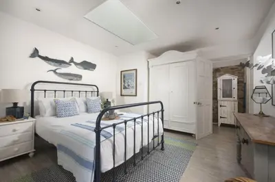 a bedroom with a bed with a black metal bed frame at Rosehendra in Saint Erth