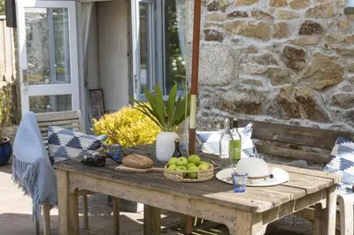 a wooden table with fruit on a patio at Rosehendra in Saint Erth