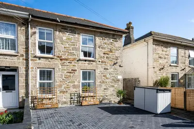 an old brick house with a driveway in front of it at Beachspoke Loft in Redruth