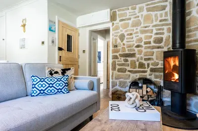 a living room with a couch and a fireplace at Beachspoke Loft in Redruth