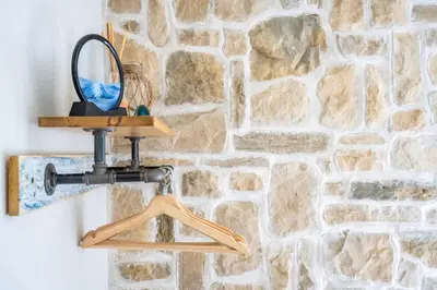 a mirror hanging on a wall next to a stone wall at Beachspoke Loft in Redruth