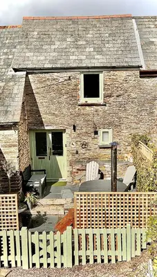 a brick house with a table and chairs in front of it at The Roundhouse Tregonce, Padstow, near the sea in St. Issey