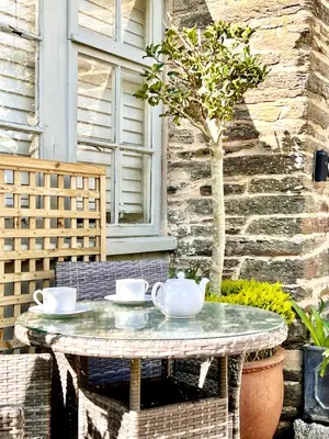 a table with cups and saucers on a patio at The Roundhouse Tregonce, Padstow, near the sea in St. Issey