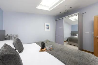 a bedroom with a white bed and a mirror at The Penthouse Forty Eight, Ocean 1 in Newquay