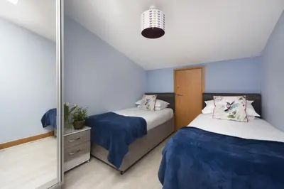a bedroom with two beds and a mirror at The Penthouse Forty Eight, Ocean 1 in Newquay