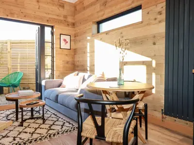 a living room with a couch and a table at Little Beach Cabin in Newquay
