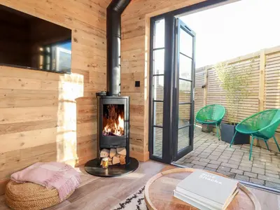 a fireplace in the living room of a house at Little Beach Cabin in Newquay