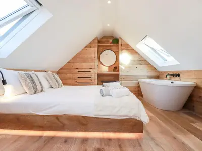 a bedroom with a bed and a bath tub at Little Beach Cabin in Newquay