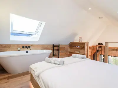a bedroom with a large bed and a bath tub at Little Beach Cabin in Newquay