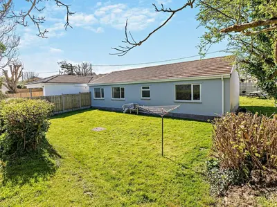a white house with a yard with a yard at 3 Bed in Bude oc-09117 in Saint Gennys