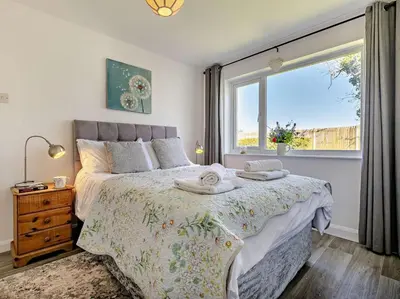 a bedroom with a bed and a large window at 3 Bed in Bude oc-09117 in Saint Gennys