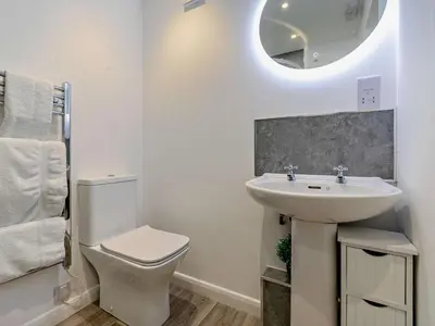 a bathroom with a sink and a toilet and a mirror at 3 Bed in Bude oc-09117 in Saint Gennys