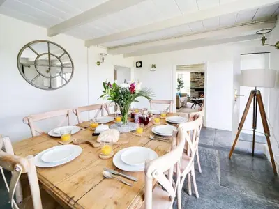 a dining room with a wooden table and chairs at Beautiful family home, sea views, large garden in Port Isaac