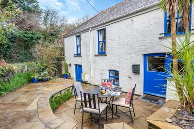 a patio with a table and chairs in front of a house at 3 Bed in Little Petherick oc-balcot in Little Petherick