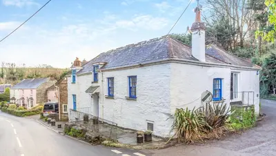 an old white house with blue windows on a street at 3 Bed in Little Petherick oc-balcot in Little Petherick