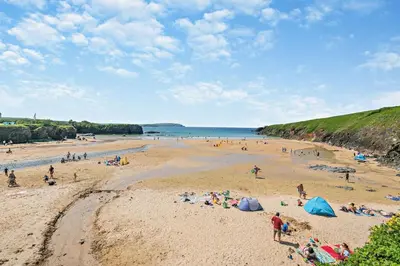 a group of people on a beach near the water at 2 Bed in Little Petherick oc-w28425 in Little Petherick